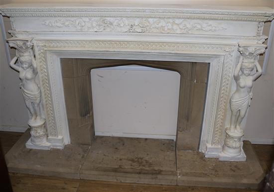 A painted carved wood fire surround with stone insert and plinth, Overall W.232cm H.136cm